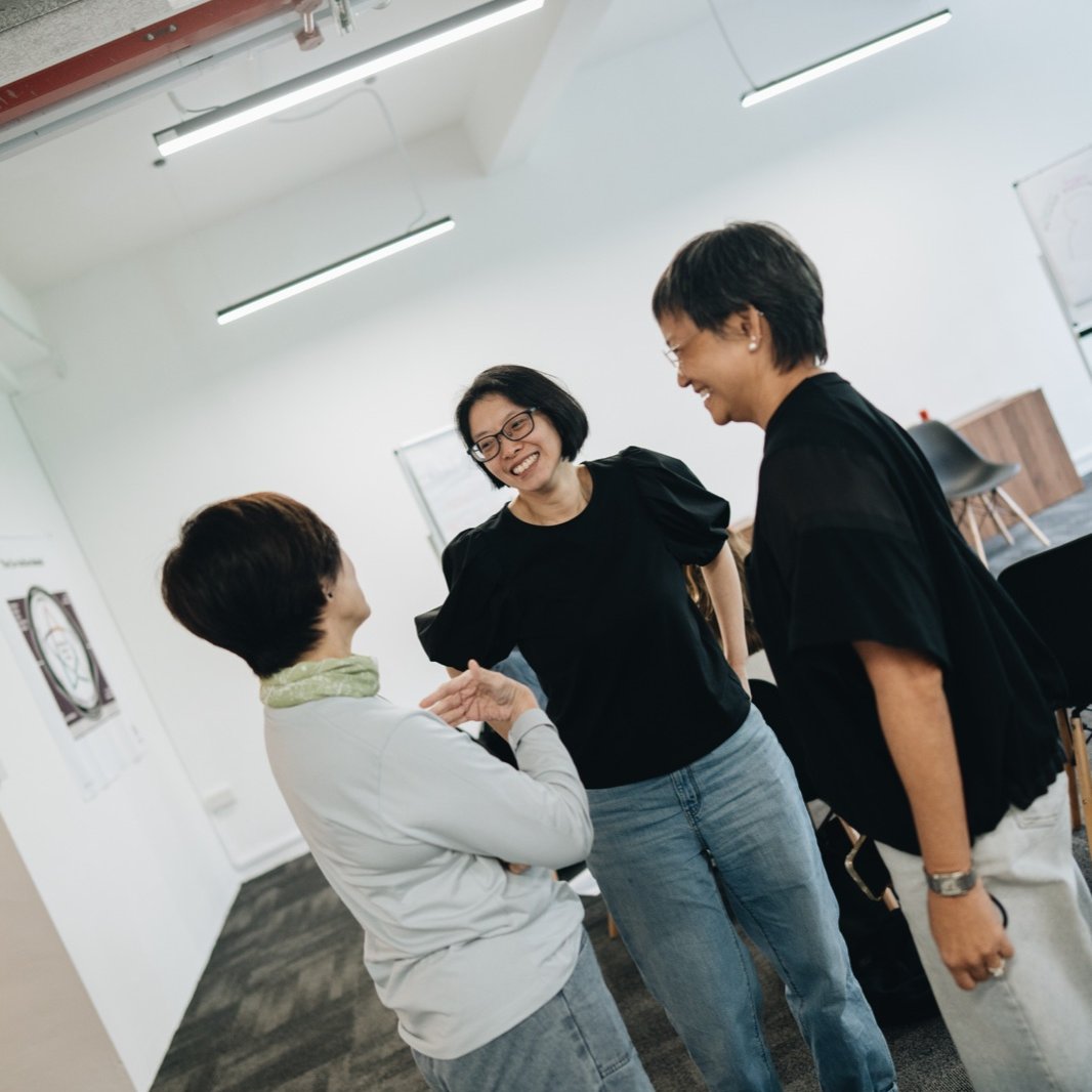 Three participants in warm conversation at an MBA training
