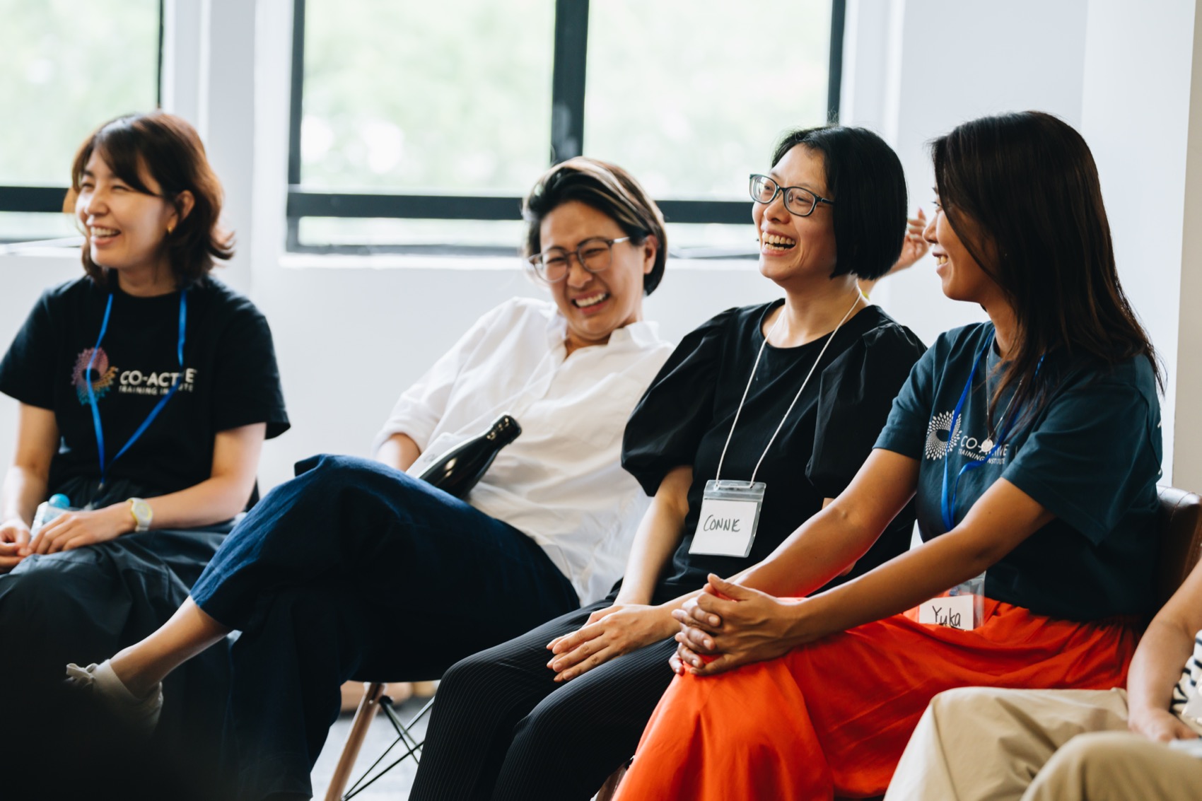 Participants sharing a laugh in a training circle