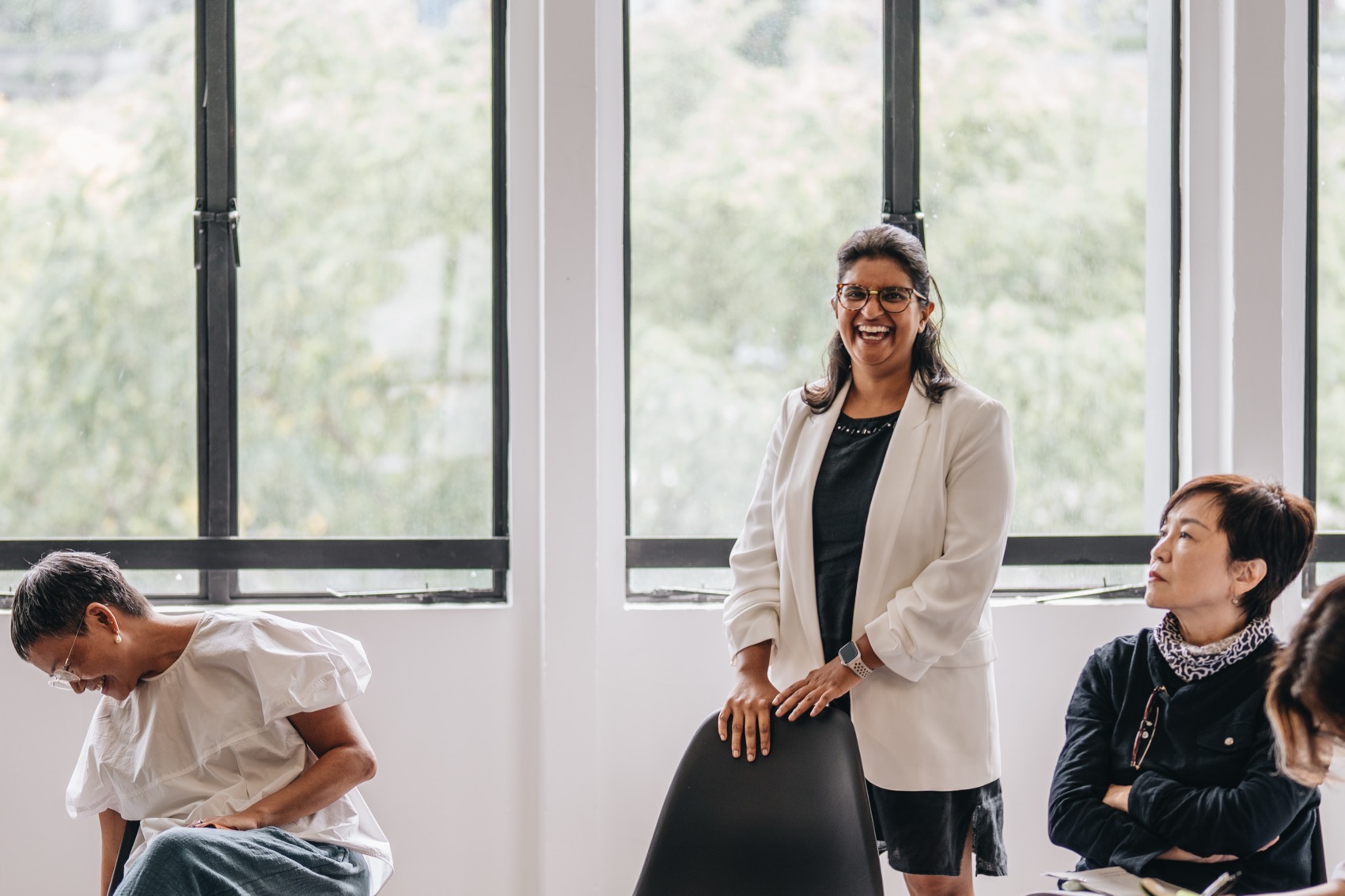 A facilitator standing with presence by the window